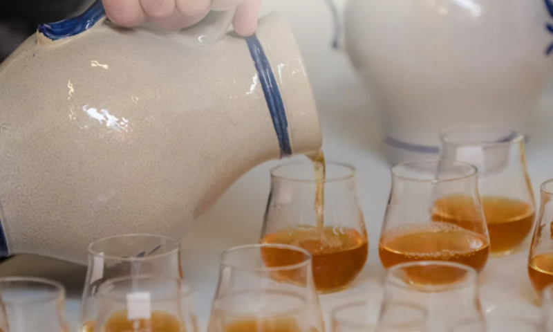 Geuze uit kruik schenken